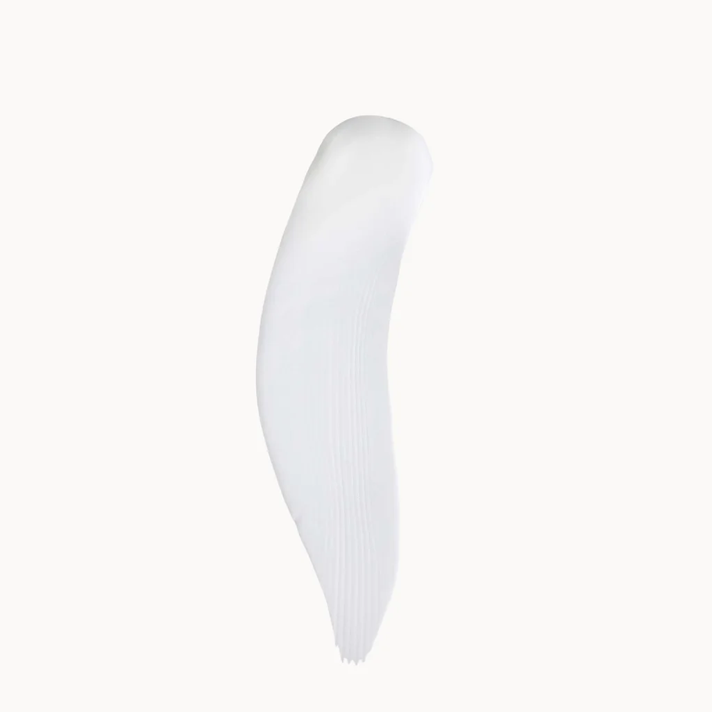 A single white cosmetic smear or swipe on a plain off-white background.