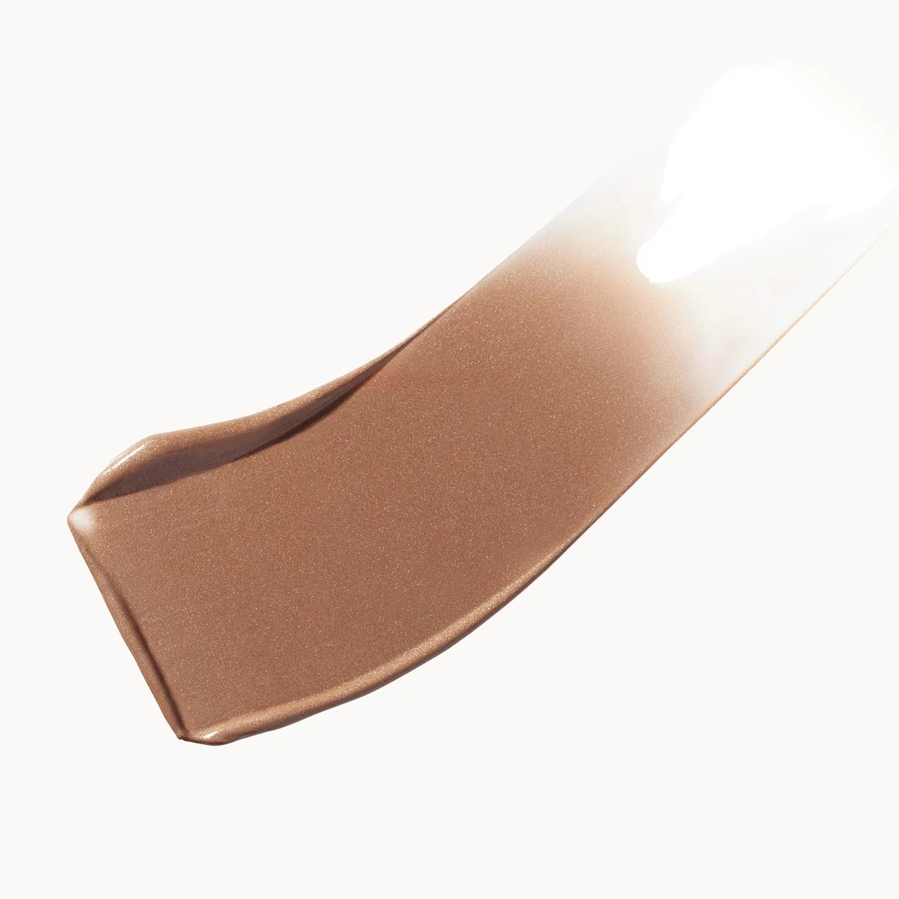 A diagonal smear of warm medium brown cosmetic cream or foundation on a clean white background, showing a smooth texture with a soft highlight.