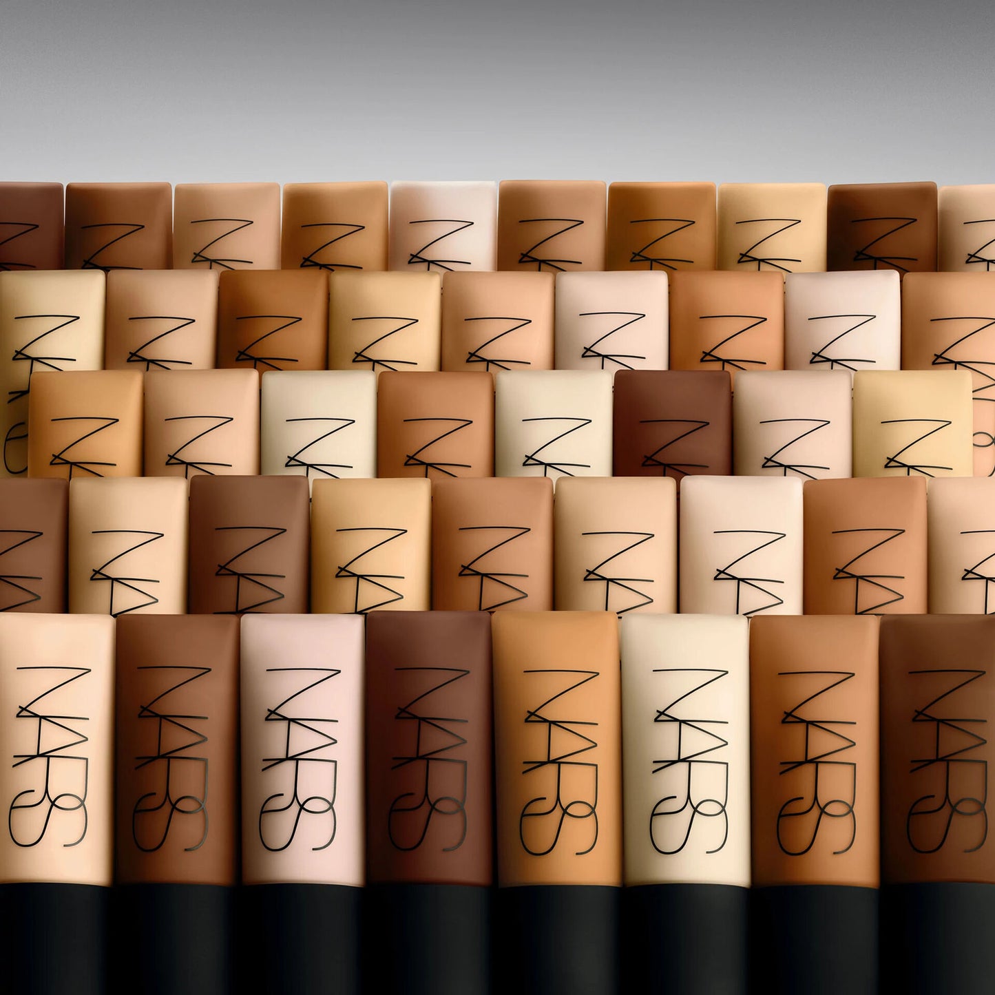 NARS makeup products arranged in a pattern with a gray background