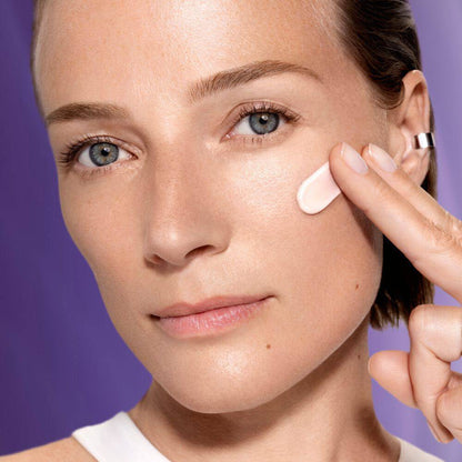 a model applying Lancôme Rénergie anti-aging SPF50 UV cream on her face