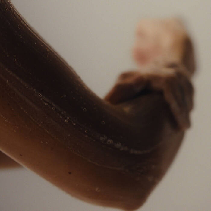 Close-up of a person's arm with a foam on a plain background