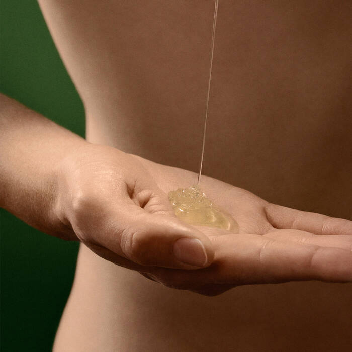 Hand receiving a drop of clear gel or cream