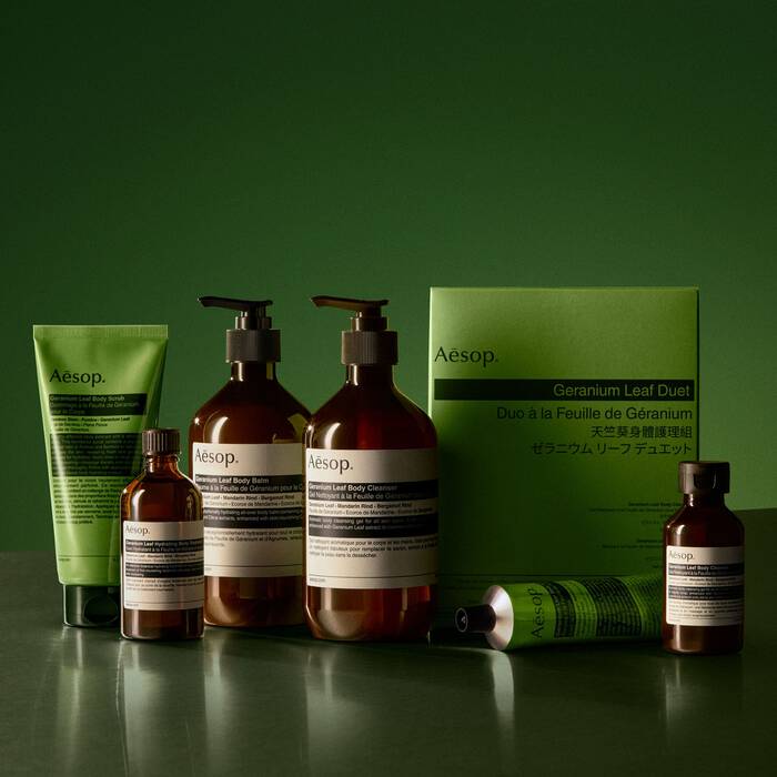 Aesop skincare products on a green background