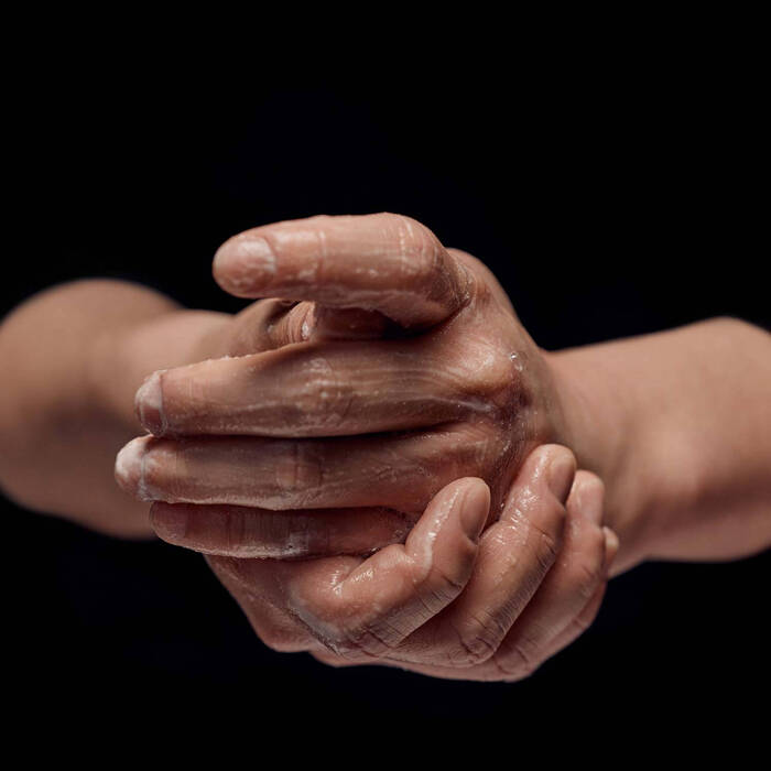 Close-up of hands with flour on a black background