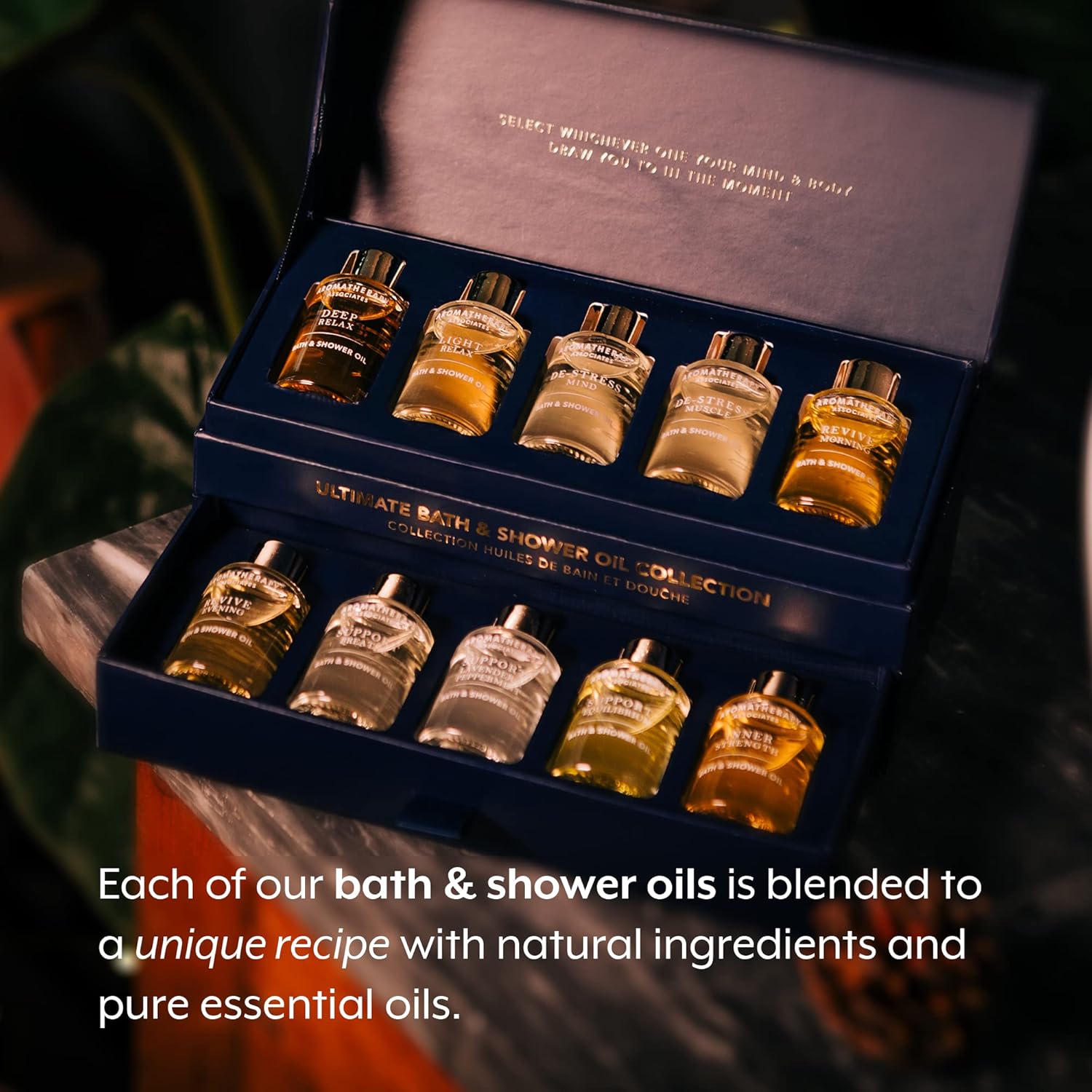 Collection of bath and shower oils in a box with text about unique recipes and natural ingredients.