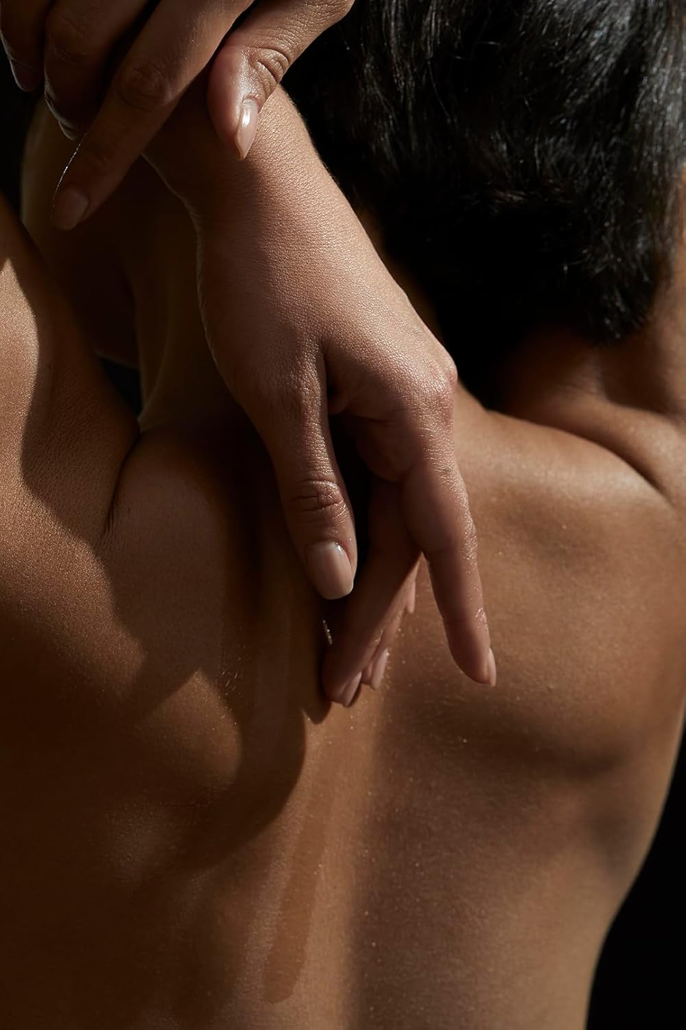 Naked person with a hand on their shoulder, in a warm-toned color palette.