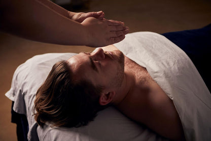 Man receiving a massage with hands applying pressure on his back.