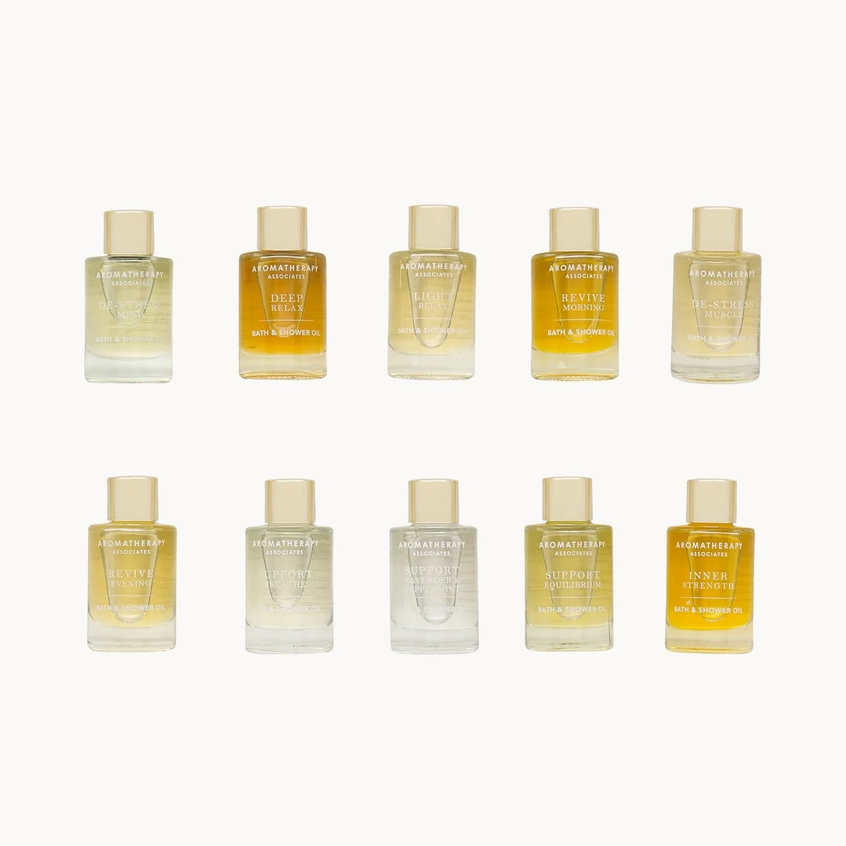 Set of 10 small Aromatherapy Associates Ultimate Wellbeing Bath & Shower Oil bottles arranged in two rows on a white background