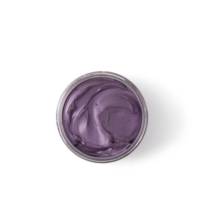 Purple cream in a small open jar on a white background