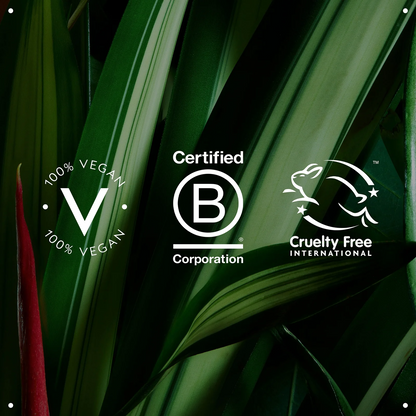 Three white certification and branding logos are overlaid on a dark green tropical leaf background: a circular '100% Vegan' logo with a large 'V', a 'Certified B Corporation' logo, and a 'Cruelty Free International' rabbit logo.