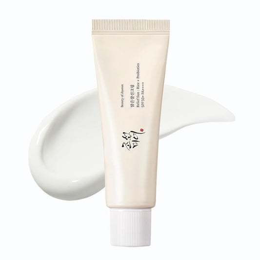 a tub of korean sunscreen with a drop of a products smeared in the background