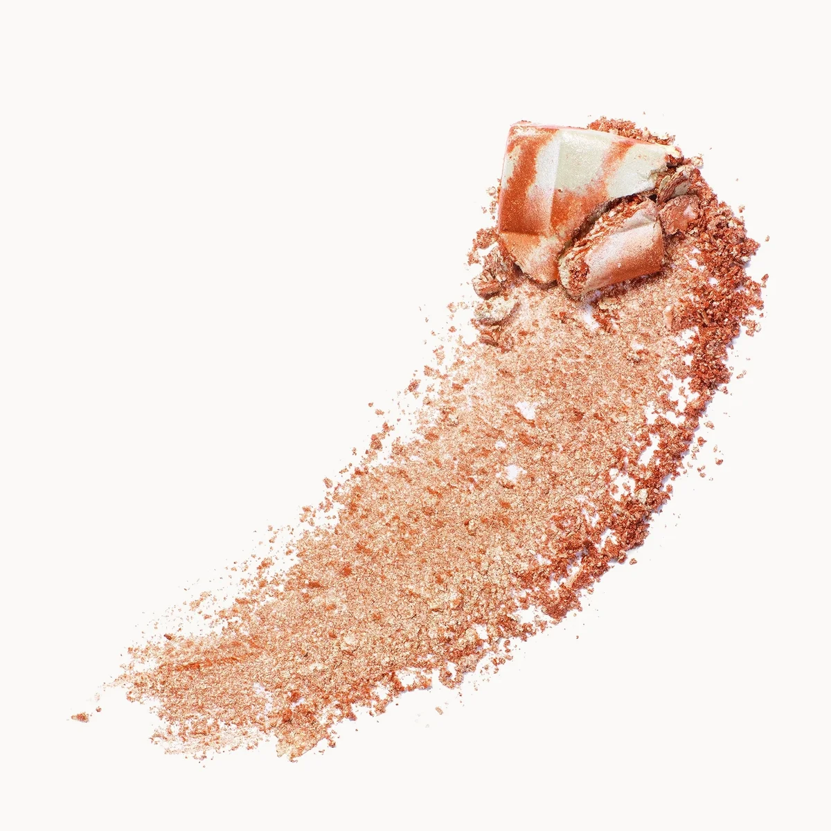 A textured swipe of shimmering rose gold cosmetic powder with a chunky shimmery chunk on top, set against a solid off-white background.