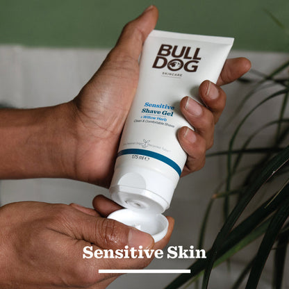 Hand holding a tube of Bulldog Sensitive Shave Gel with a blurred background