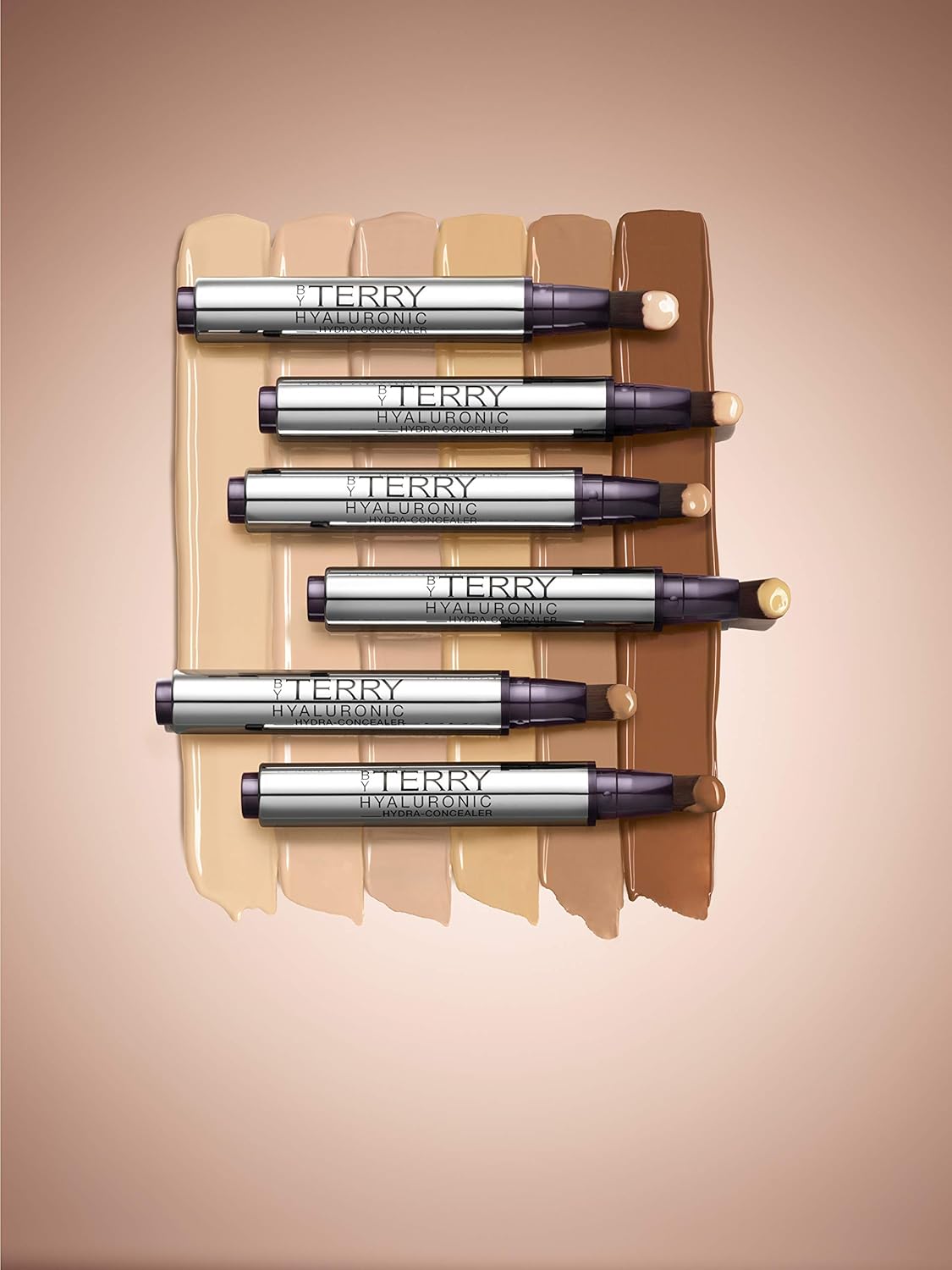 Set of By Terry makeup products on a beige background