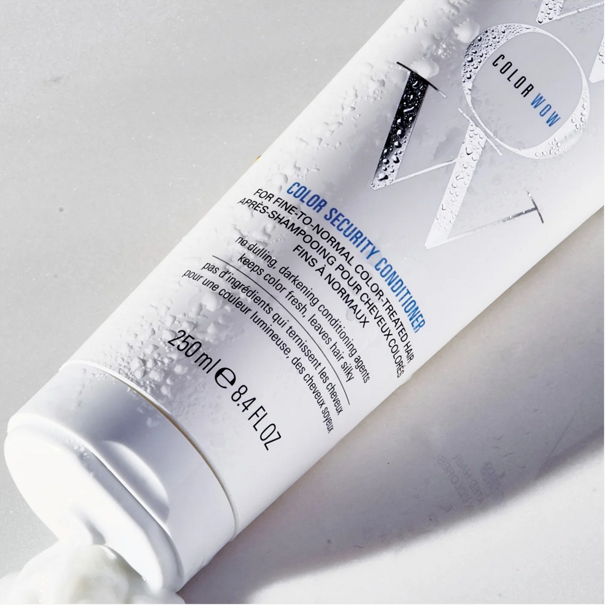 A white squeeze tube of Color Wow Color Security Conditioner for pre-professional colorists, shown diagonally on a light gray background with a squeeze of cream visible at the bottom.