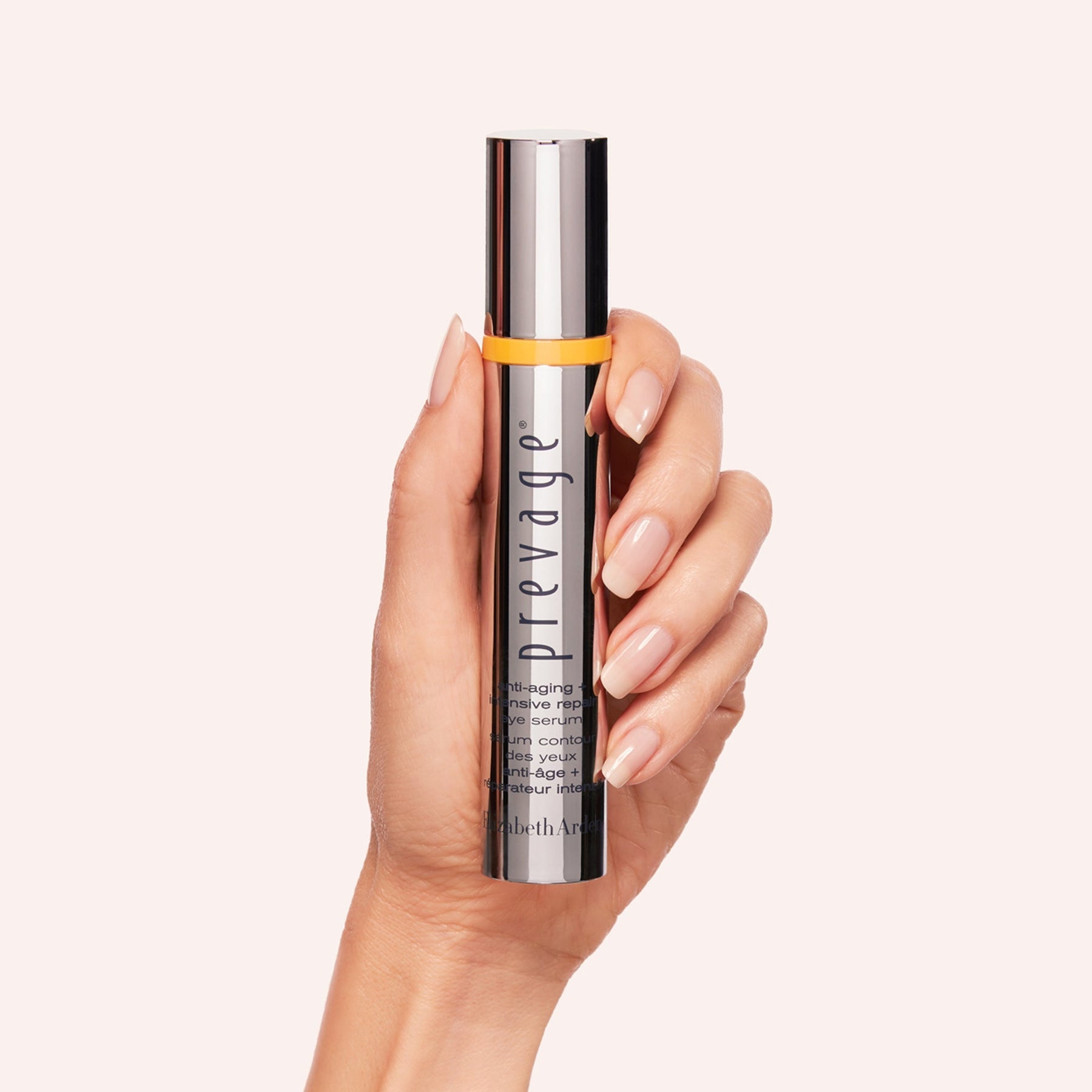 Hand holding a Elizabeth Arden Prevage Intensive Eye Serum tube against a light background
