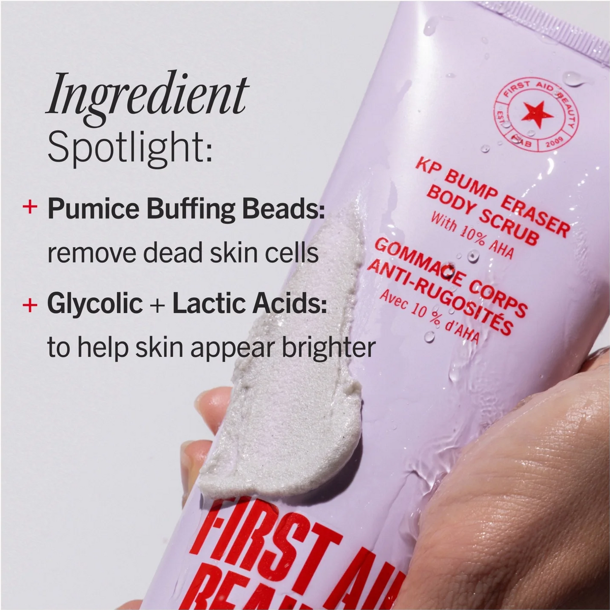 A hand holds a tube of First Aid Beauty KP Bump Eraser Body Scrub against a light gray background with text detailing its ingredients.