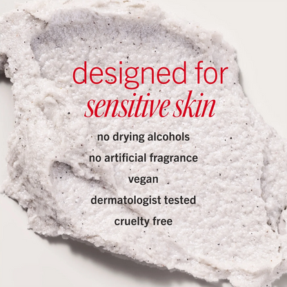 A close-up of a textured white exfoliating or cleansing scrub with black specks, overlaid with text reading 'designed for sensitive skin' and additional product claims on a light background.