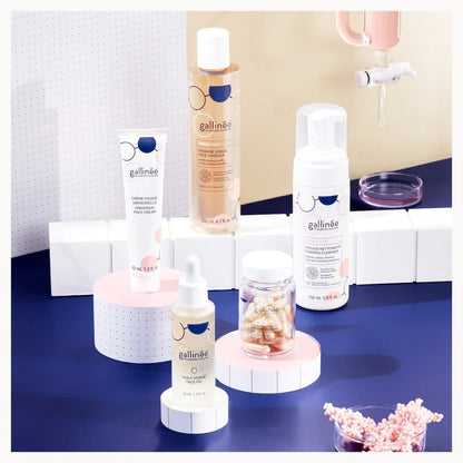 Gallinèse skincare products on a blue surface with a white wall background