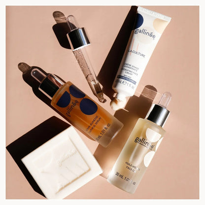 Gallinèe skincare products including bottles and a tube on a beige background