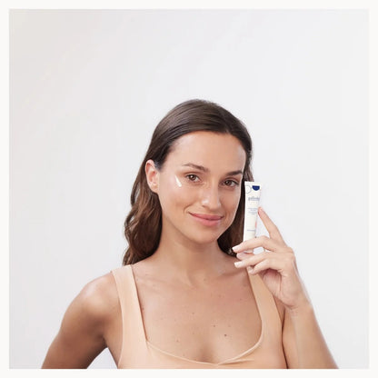 Woman holding a skincare product against a white background
