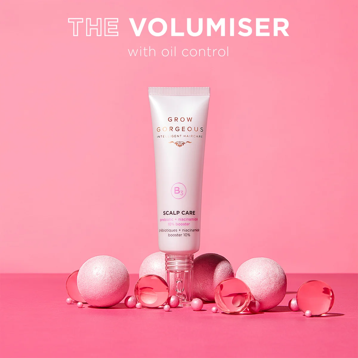 Tube of 'Grow Gorgeous' scalp care product with decorative items on a pink background