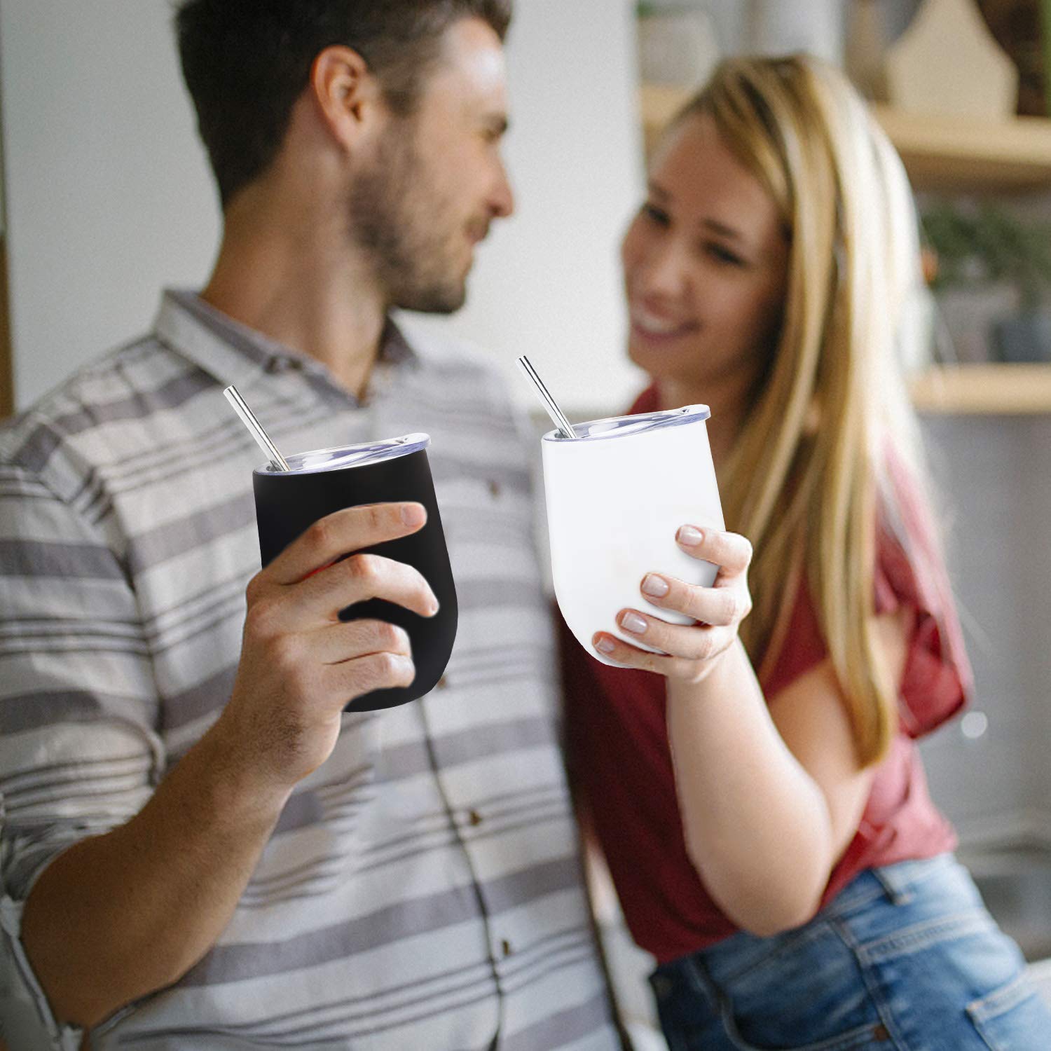 Man and woman holding insulated tumblers with straws in a casual setting