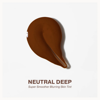A teardrop-shaped smear of deep brown skin tint on a light gray background, with the text 'NEUTRAL DEEP' and 'Super Smoother Blurring Skin Tint' below.
