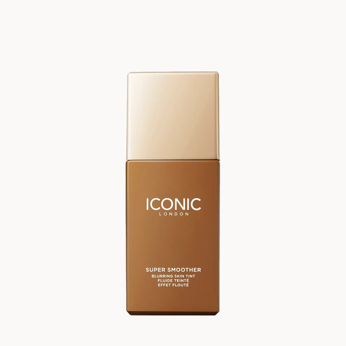 A rectangular cosmetic bottle labeled 'ICONIC LONDON Super Smoother' in a warm brown shade, with a metallic gold cap, centered on a plain white background.