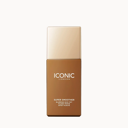 A rectangular cosmetic bottle labeled 'ICONIC LONDON Super Smoother' in a warm brown shade, with a metallic gold cap, centered on a plain white background.