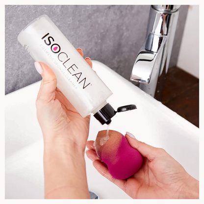 Person using ISO CLEAN product on a pink sponge over a sink.