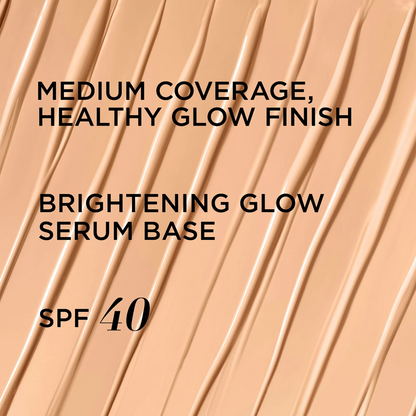 A close-up cosmetic smear graphic showing a warm light beige foundation or serum base with text reading 'MEDIUM COVERAGE, HEALTHY GLOW FINISH', 'BRIGHTENING GLOW SERUM BASE', and 'SPF 40'.