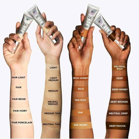 Hands holding CC cream applicators with color swatches on a white background