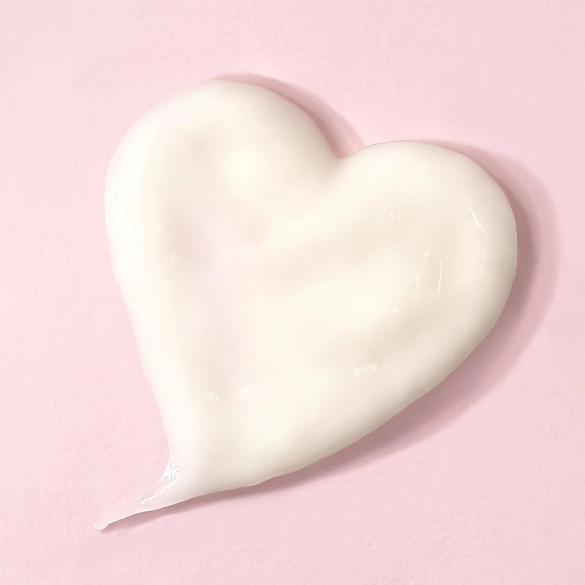 Heart-shaped night mask product sample on a pink background