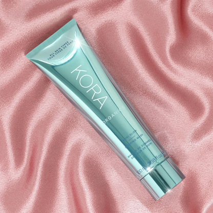 Kora skincare tube on a pink textured background