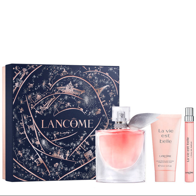 Lancôme La Vie Est Belle gift set featuring a dark blue illustrated box, a pink perfume bottle, a pink body lotion tube, and a small pink travel spray bottle on a white background.