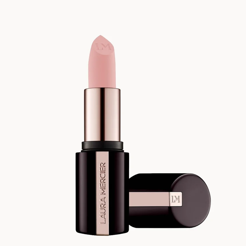 Laura Mercier lipstick in a pale pink shade, shown with its cap off and standing next to the open tube on a clean white background.