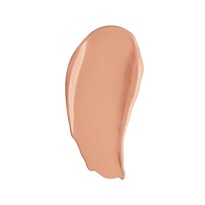 A smooth, glossy smear of liquid foundation or concealer in a warm peach-beige shade, centered on a solid white background.