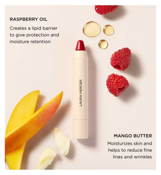 A Laura Mercier lip balm tube with a red bullet and cream-colored casing, styled on a light beige background with raspberries, mango slices, and text describing raspberry oil and mango butter ingredients.
