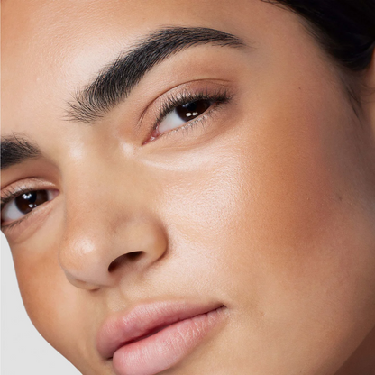 Close-up of a person's face wearing Laura Mercier Tinted Moisturiser Bronzer 03 Sunbeam