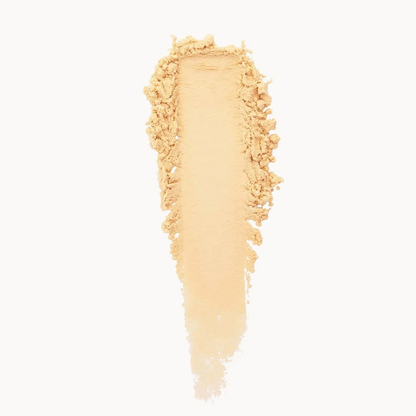 A vertical smear of light beige pressed powder, likely a cosmetic powder or pigment, centered on a solid white background.
