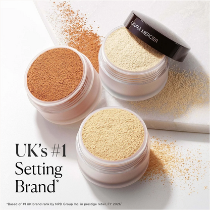 Three open jars of Ultra Mercer setting powder in warm beige, tan, and light cream shades, arranged on a white surface with loose powder scattered around. One jar lid is propped up, showing the black Ultra Mercer branding.