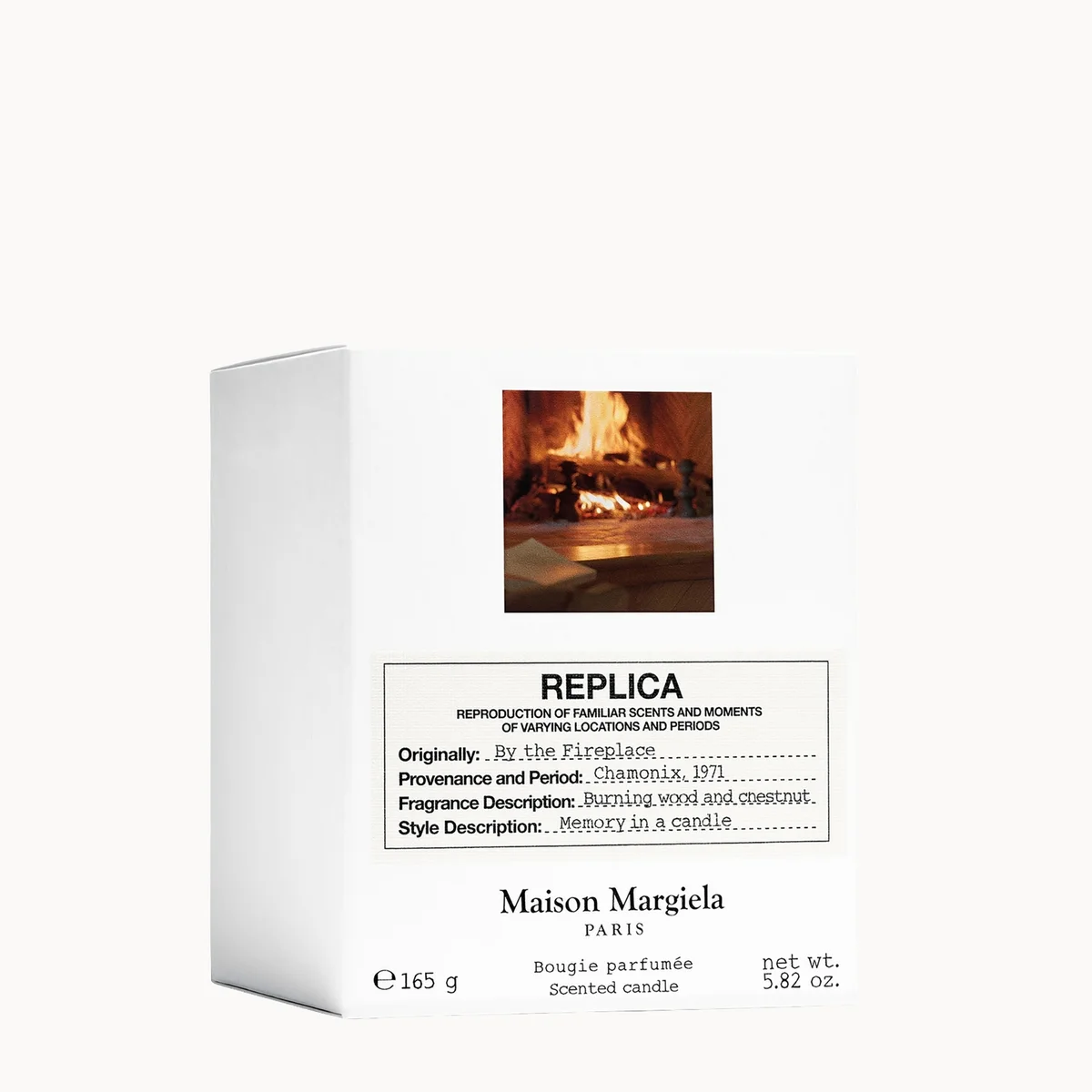 Maison Margiela Replica scented candle packaging box, featuring a white design with a small image of a burning fireplace and product details printed in black text.