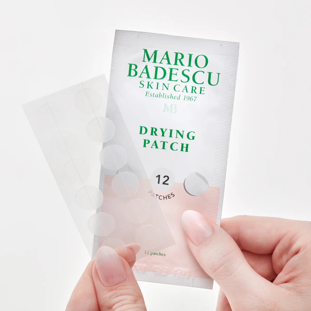 Mario Badescu skin care drying patch packaging held by a hand on a white background