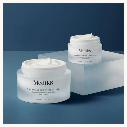 Two jars of Medik8 Advanced Night Restore cream on a blue background