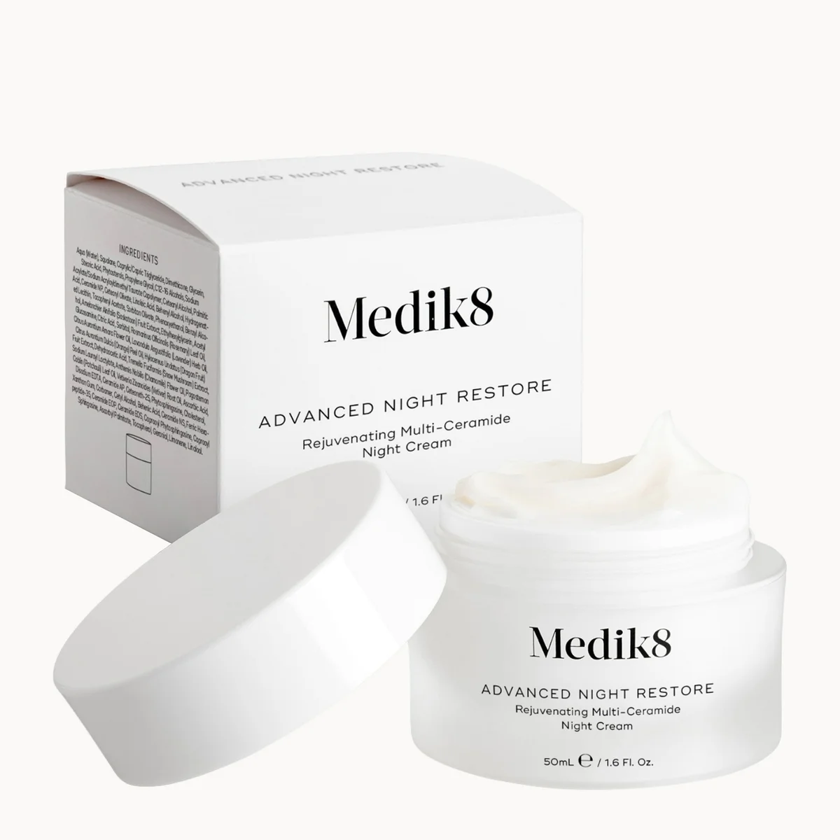 Medik8 Advanced Night Restore night cream jar with its lid off, placed in front of its white product box on a clean white background.
