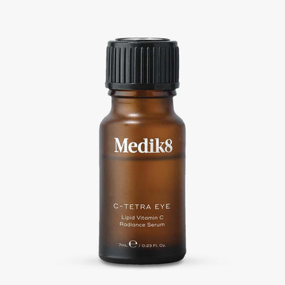 Medik8 C-Tetra Eye Lipid Vitamin C Radiance Serum in an amber glass bottle with a black ribbed cap, centered on a light gray background.