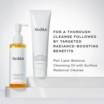 Mediks skincare set featuring a clear bottle of golden liquid cleansing oil and a white tube of surface radiant cleanser, displayed on a white platform with promotional text.