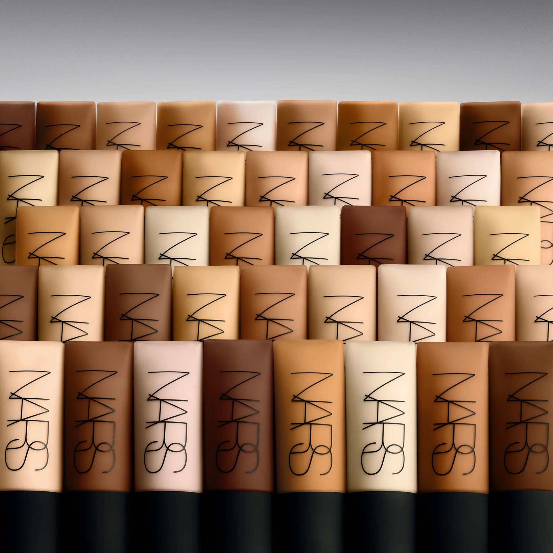 NARS makeup products arranged in a pattern with a gray background