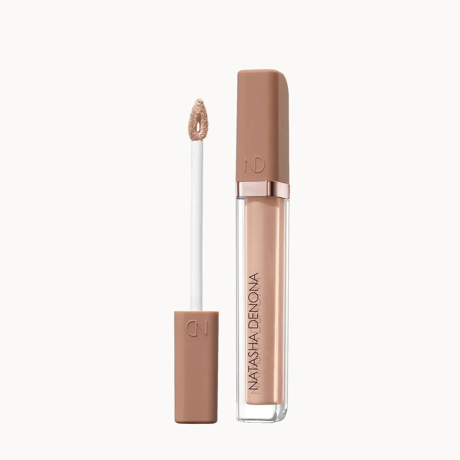 A tube of Natasha Denona liquid concealer with its applicator wand shown beside it, on a clean off-white background.